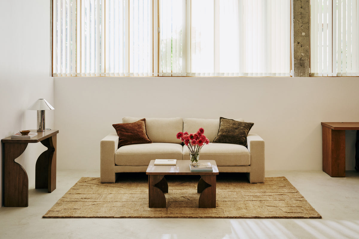 salon lumineux avec tapis Shard à poils longs, canapé côtelé écru et table basse en bois