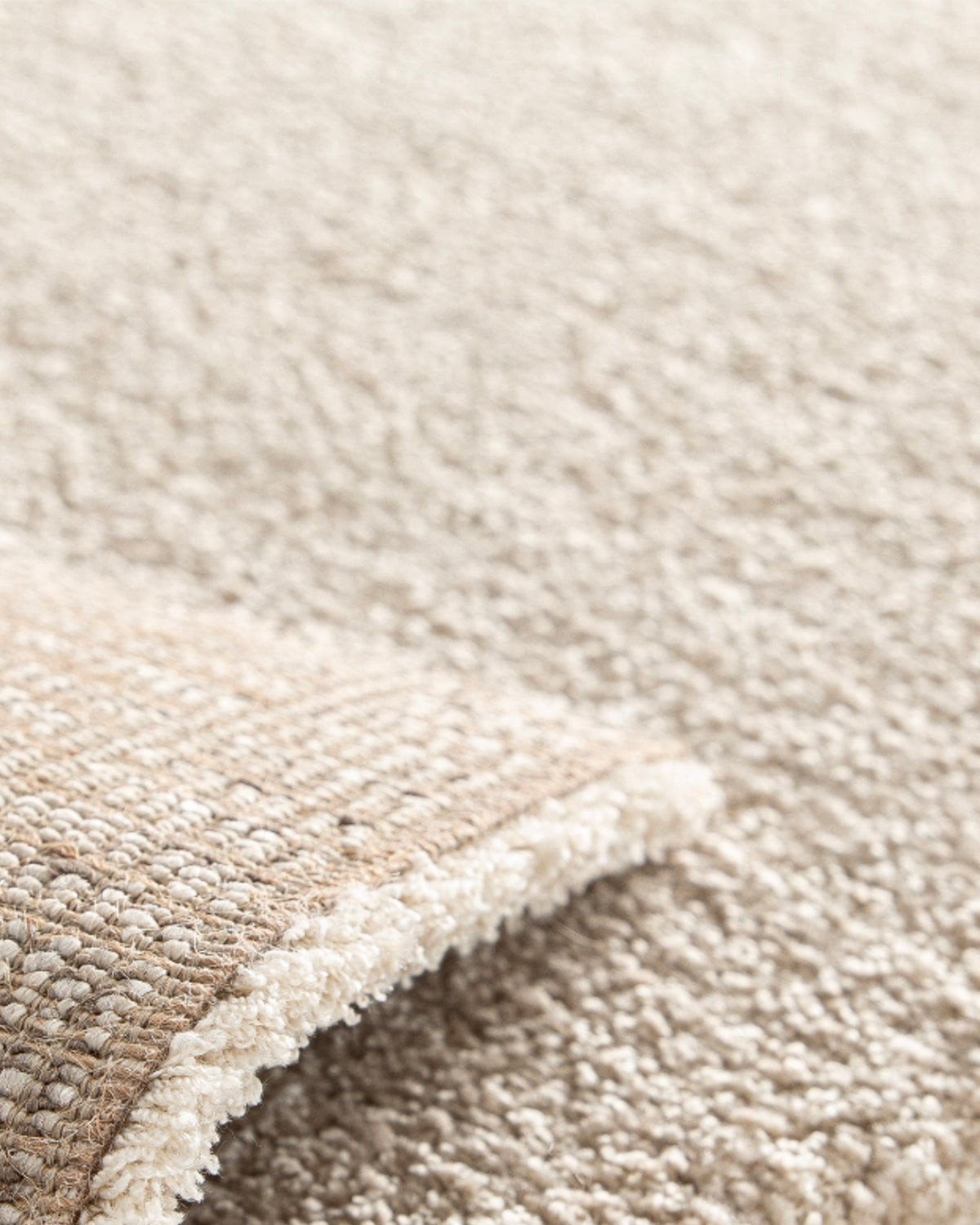 gros plan sur l'envers tissé et la lisière d'un tapis de salon Folio beige en petit format