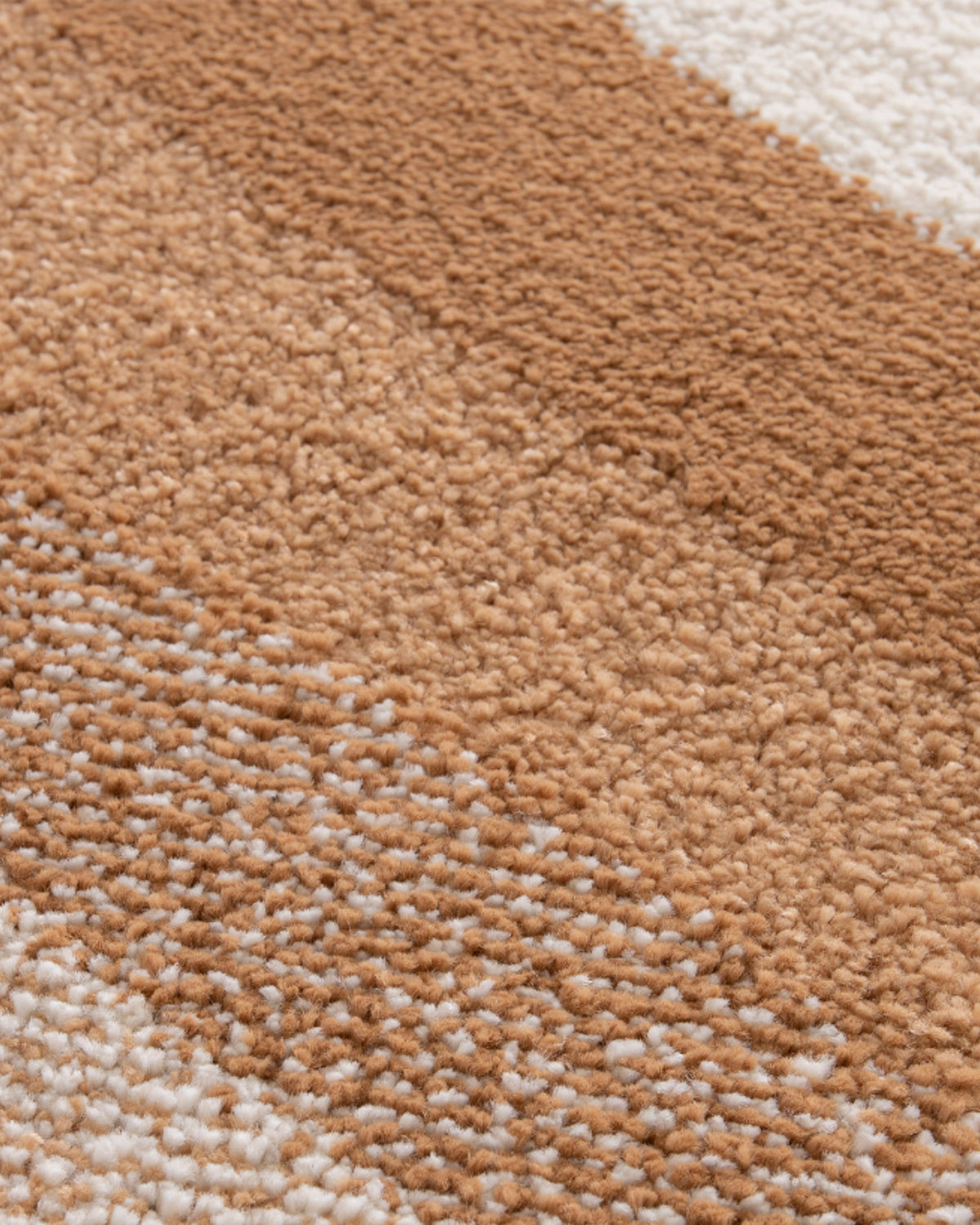 gros plan sur les bandes caramel et sable juxtaposées d'un tapis de salon Levante écru