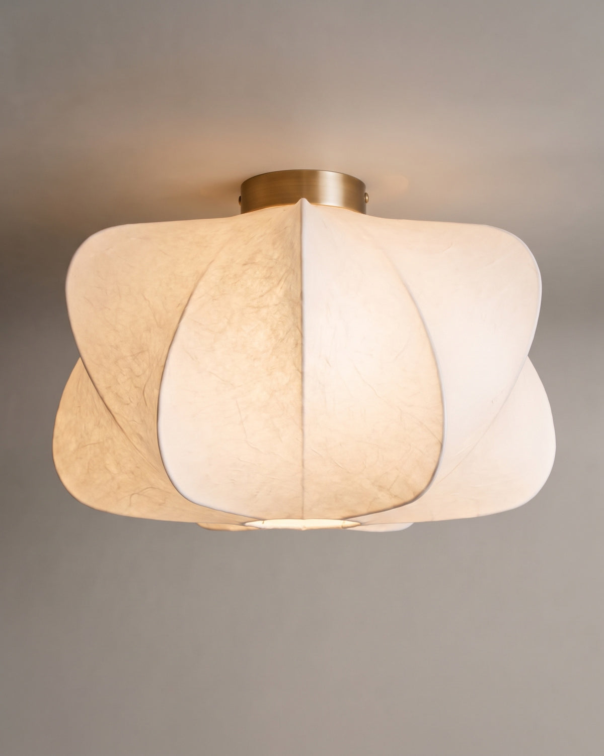 plafonnier AICHI allumé, ses volumes en fibre blanche diffusent une lumière chaude