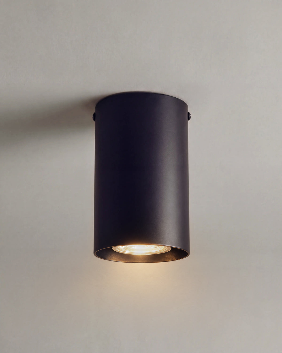spot de plafond BAILEY allumé, cylindre en métal noir mat et faisceau dirigé vers le bas