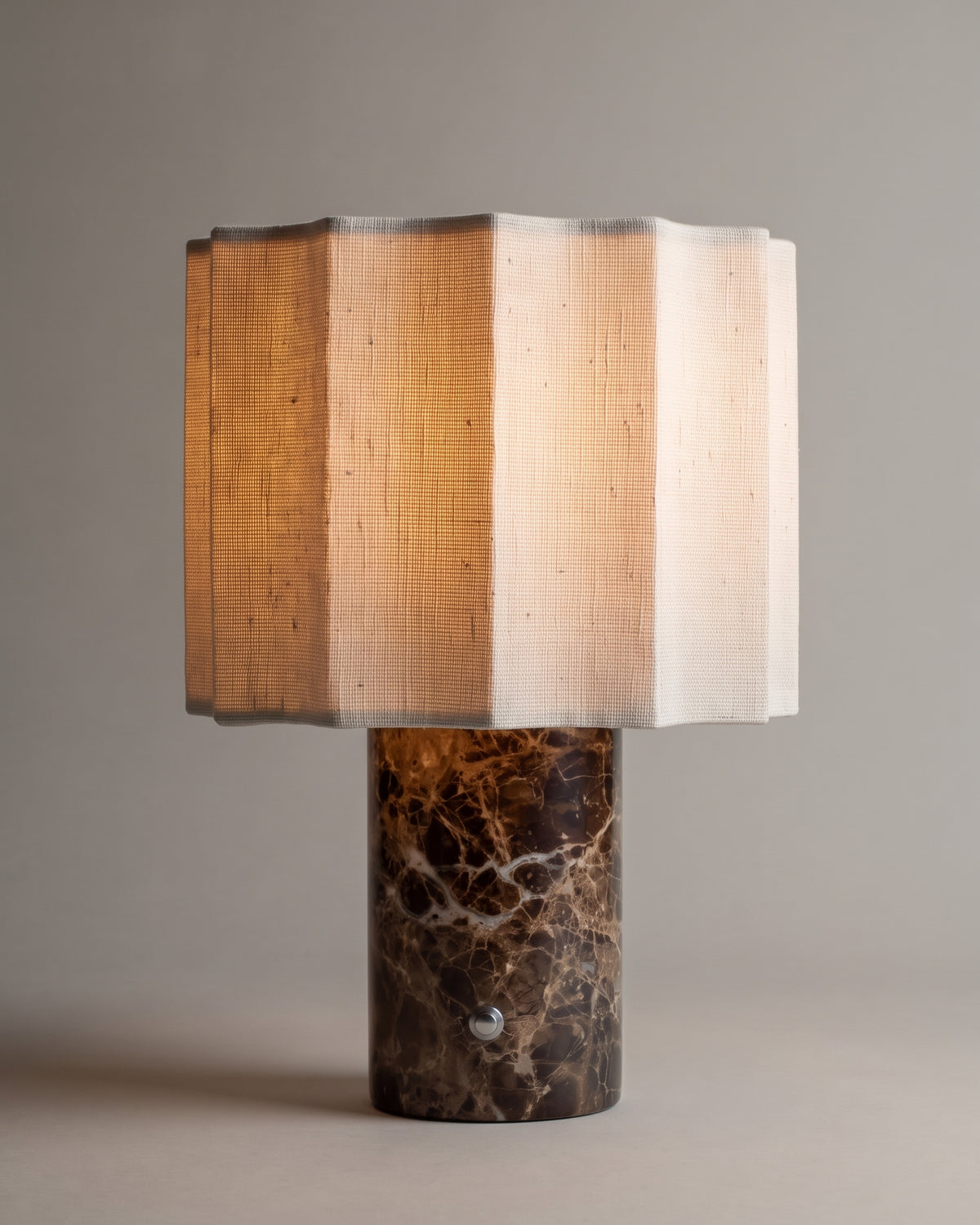 lampe de table BRIDGET allumée, pied en marbre Dark Emperador et abat-jour en lin à pans