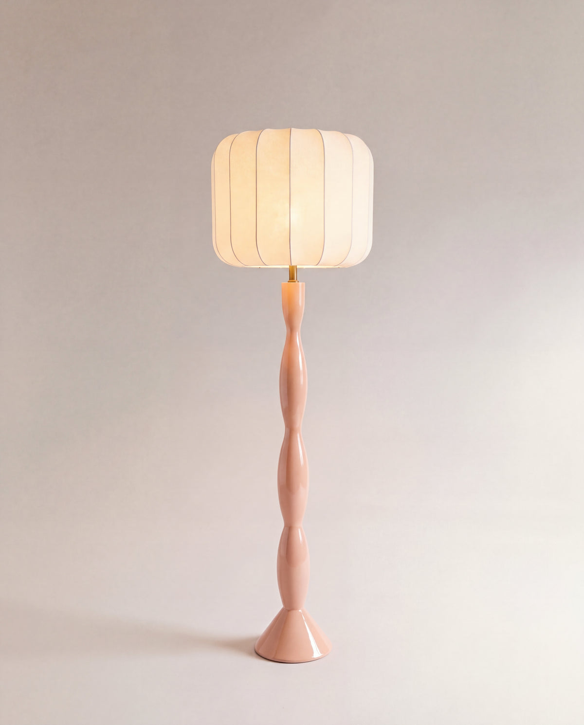lampadaire HANAKI allumé, abat-jour écru en lanterne sur un fût tourné rose laqué