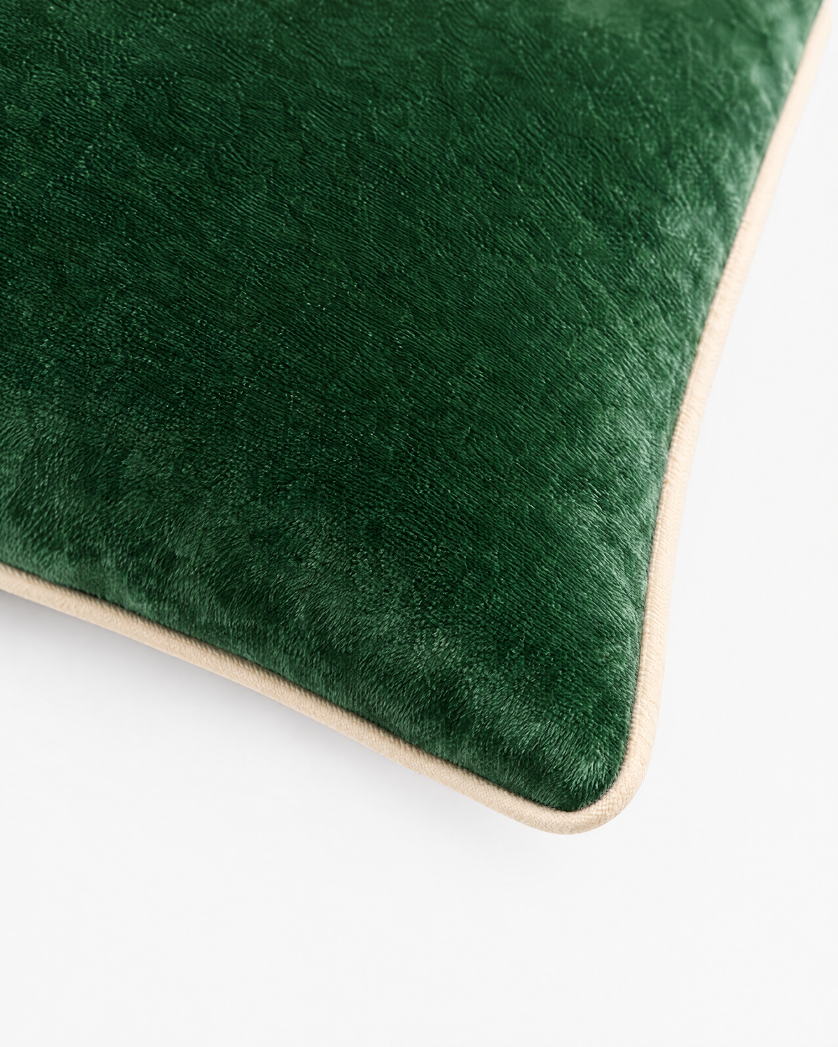 gros plan sur le passepoil écru et la texture du velours vert sapin du coussin LODGE