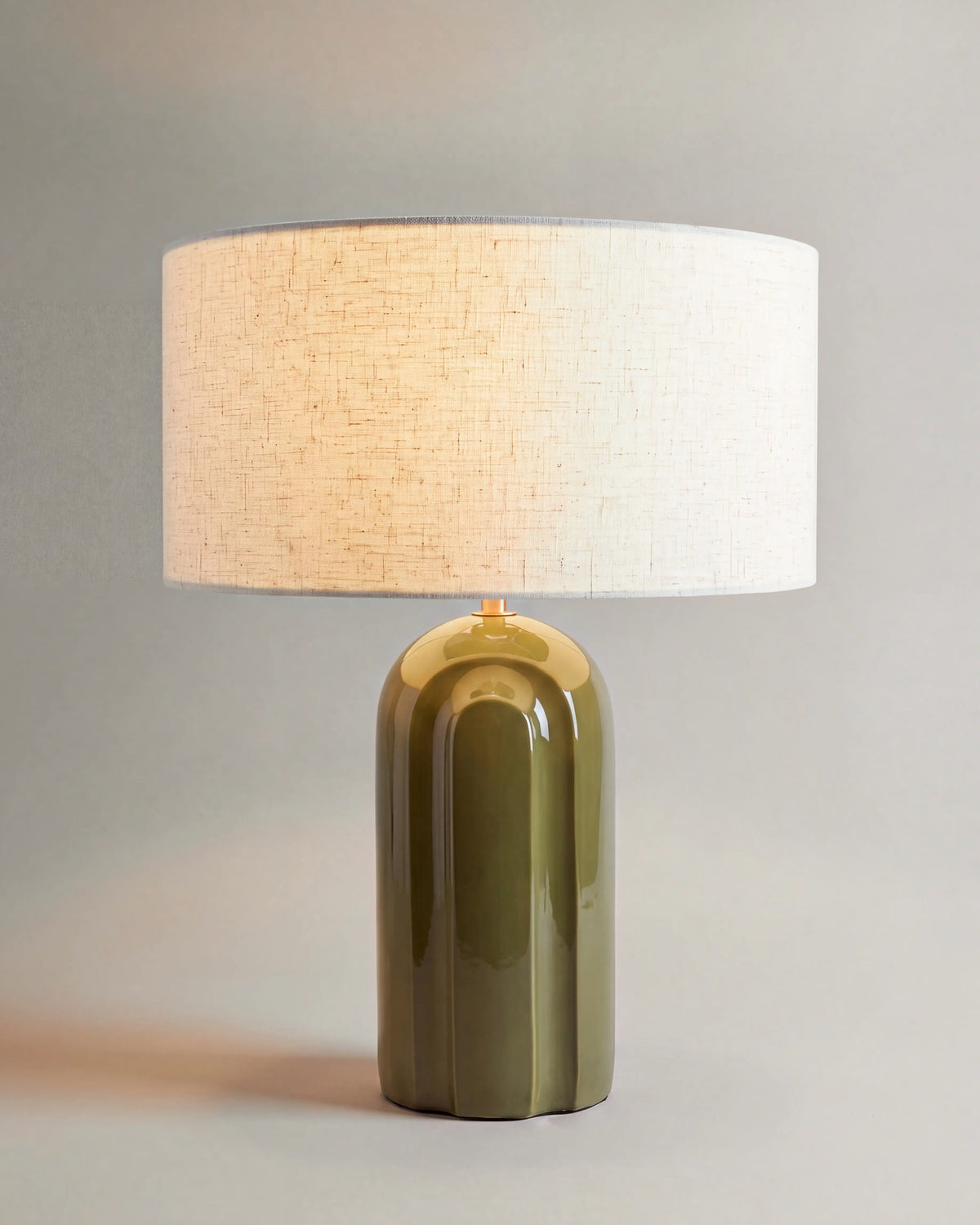lampe de table LEYANIS allumée, pied en céramique vert kaki brillante et abat-jour écru