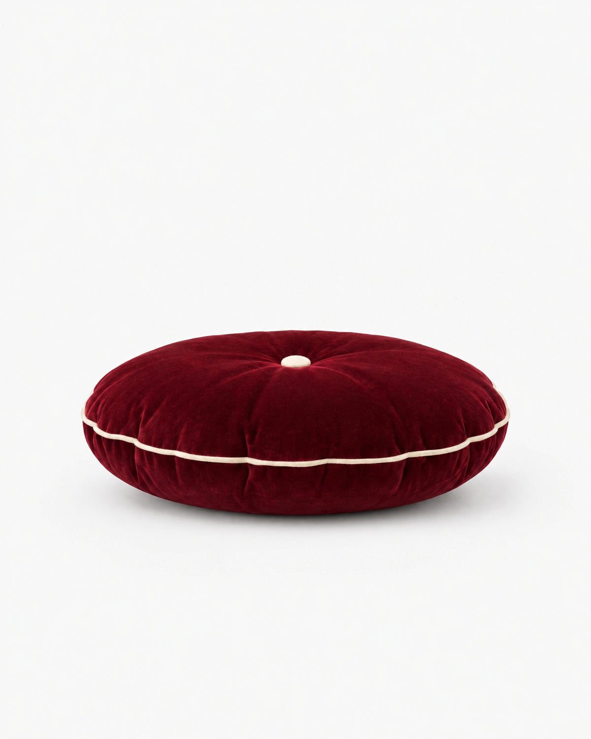 coussin rond MOON en velours rouge framboise vu de profil, épaisseur et passepoil écru visibles