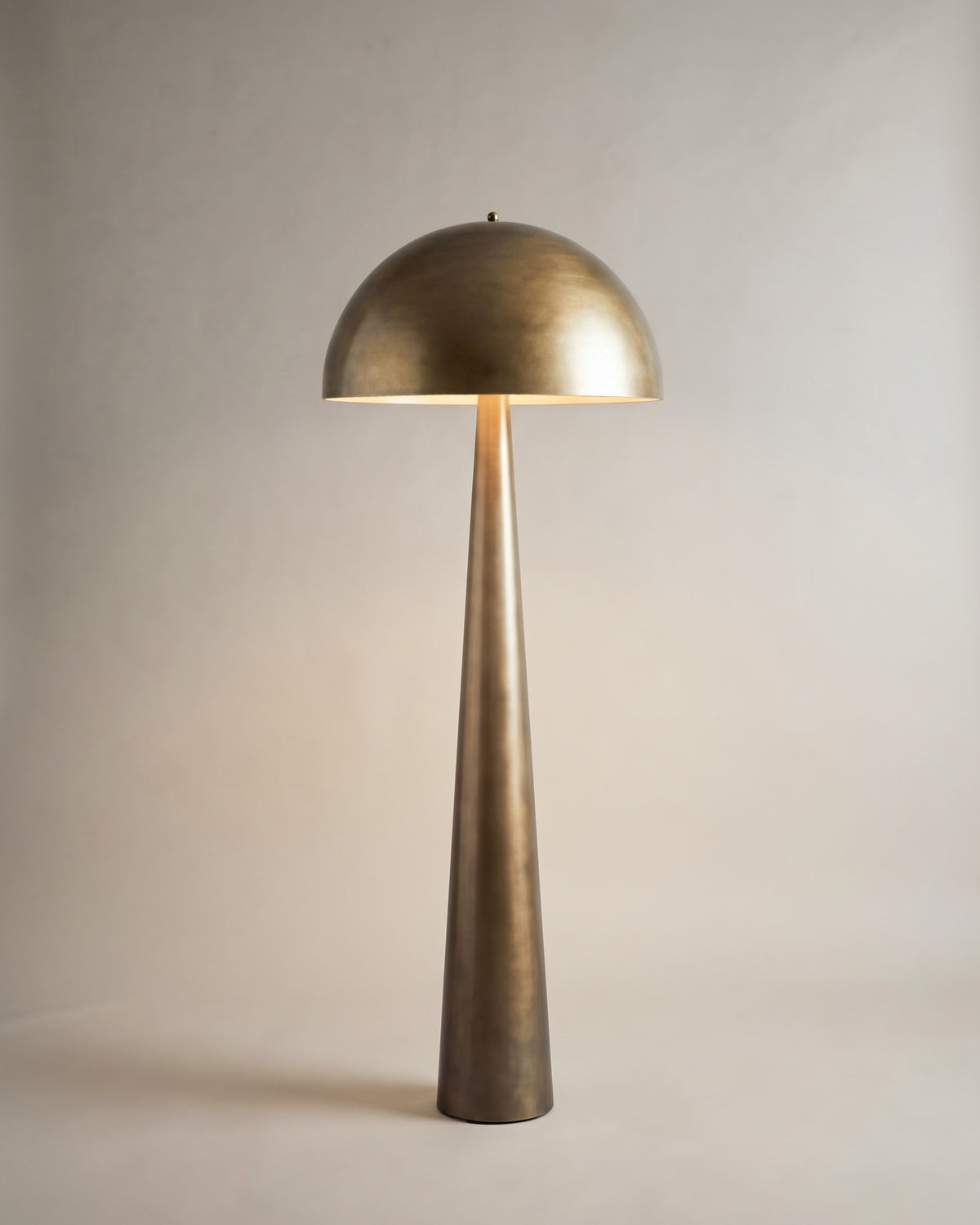 lampadaire OLYMPIA en bronze allumé, son dôme hémisphérique renvoie la lumière au sol