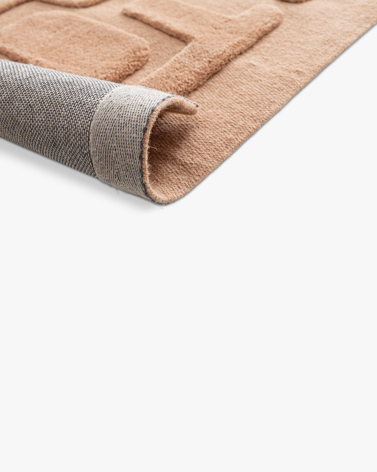 gros plan sur l'envers tissé anthracite et le bord d'un tapis de salon Maze caramel