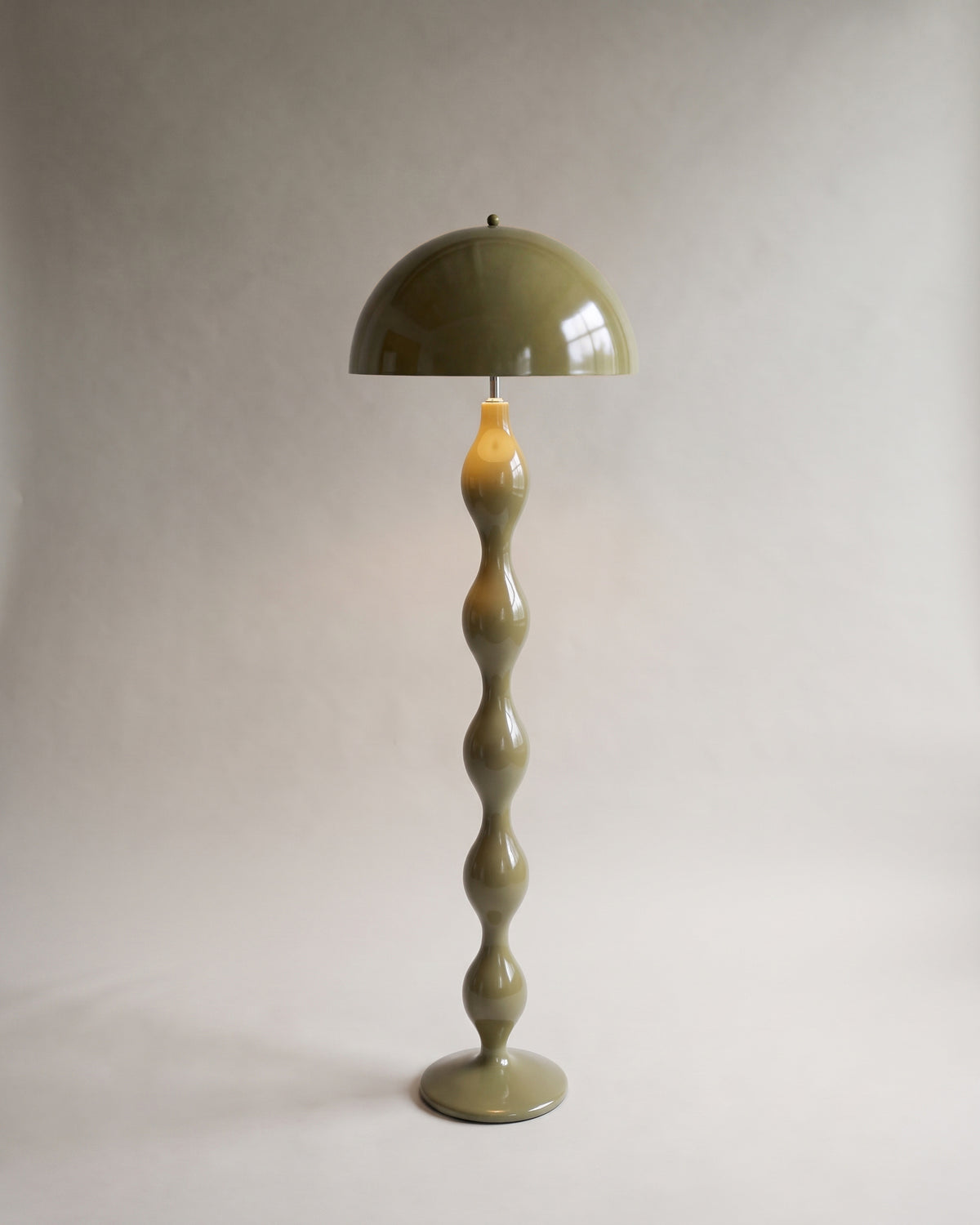 lampadaire POWERS vert kaki laqué brillant allumé, dôme et fût à renflements arrondis
