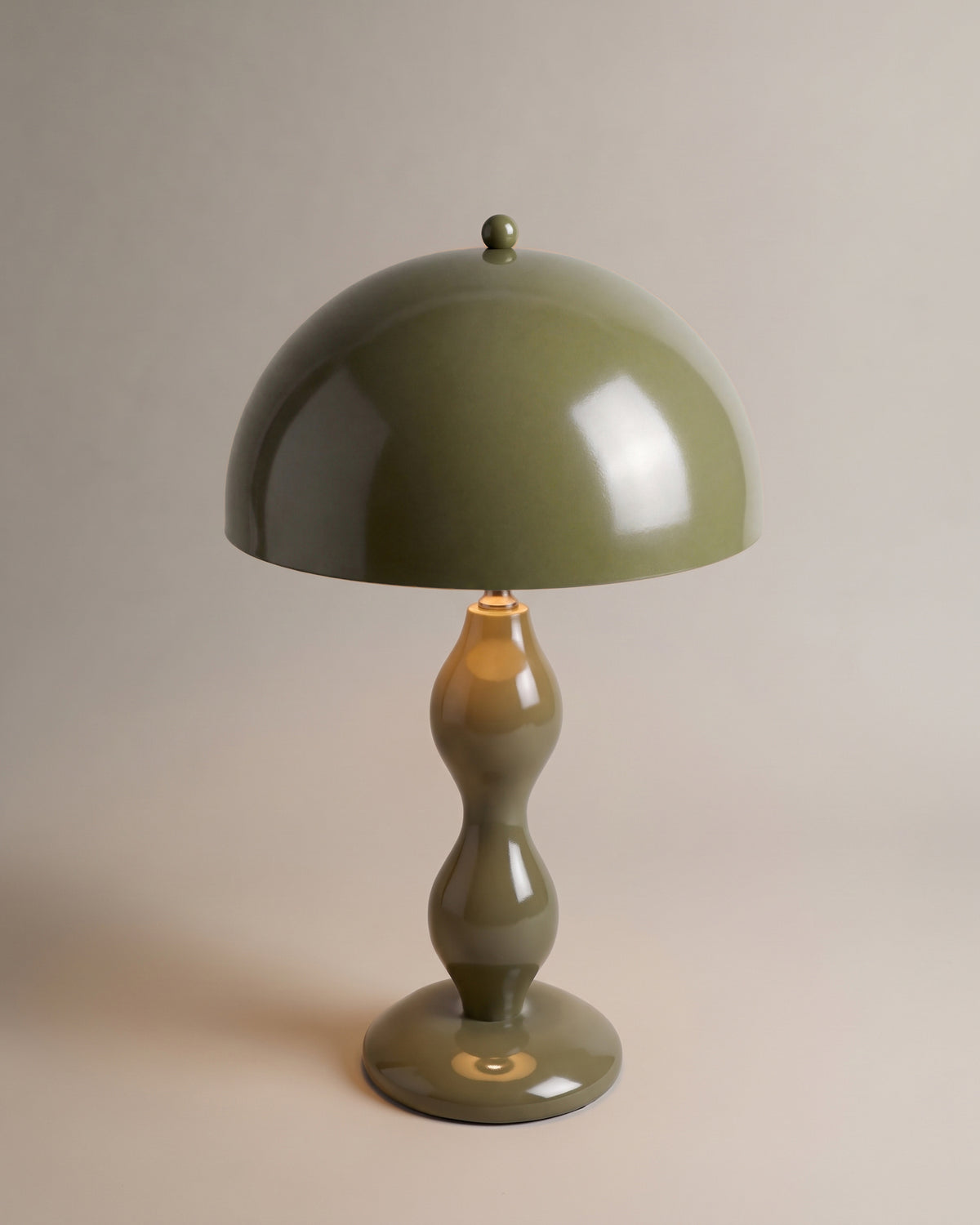 lampe de table POWERS vert kaki laqué brillant allumée, dôme et fût tourné en balustre