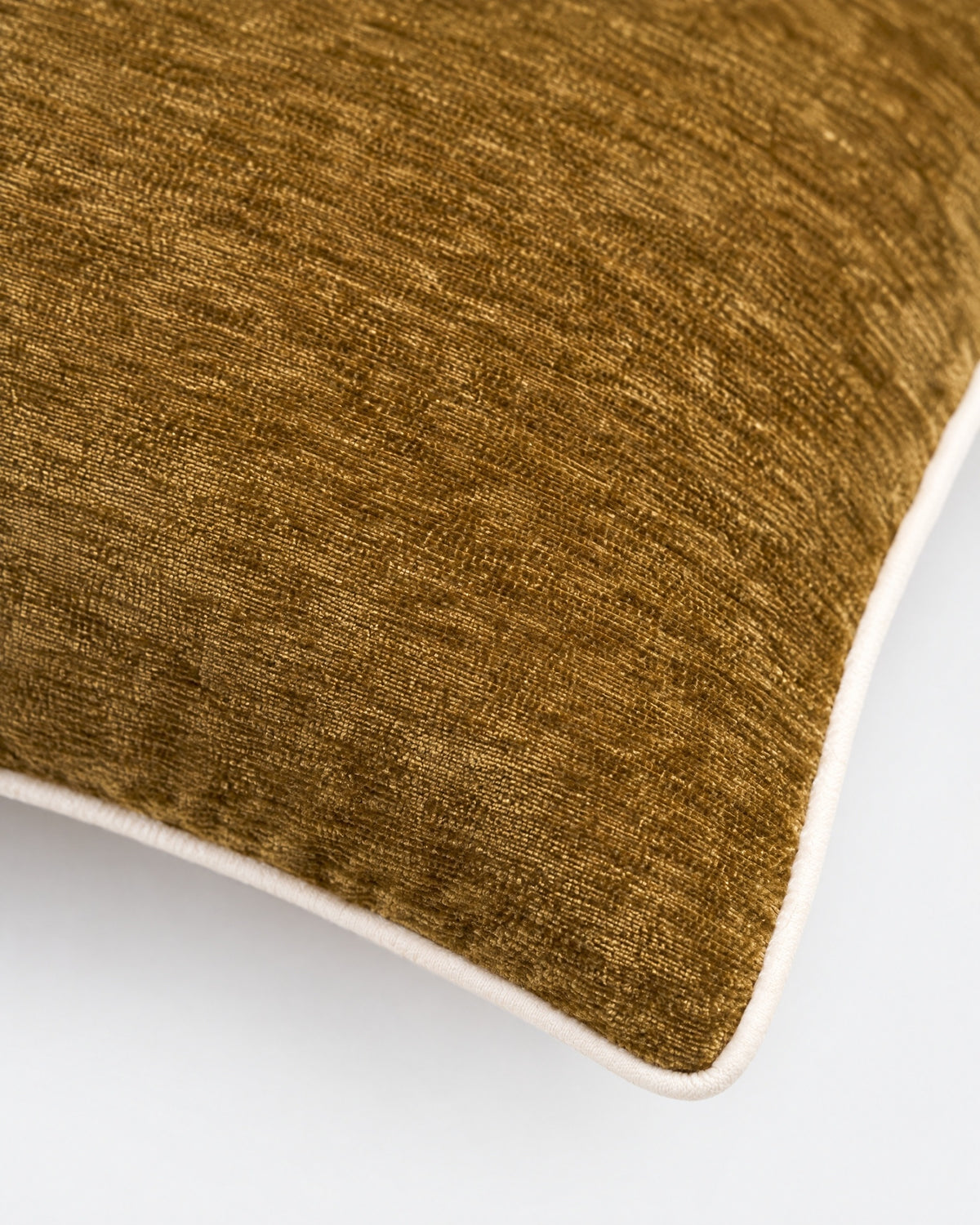 gros plan sur le passepoil écru et la trame du velours chenille marron ocre du coussin LODGE