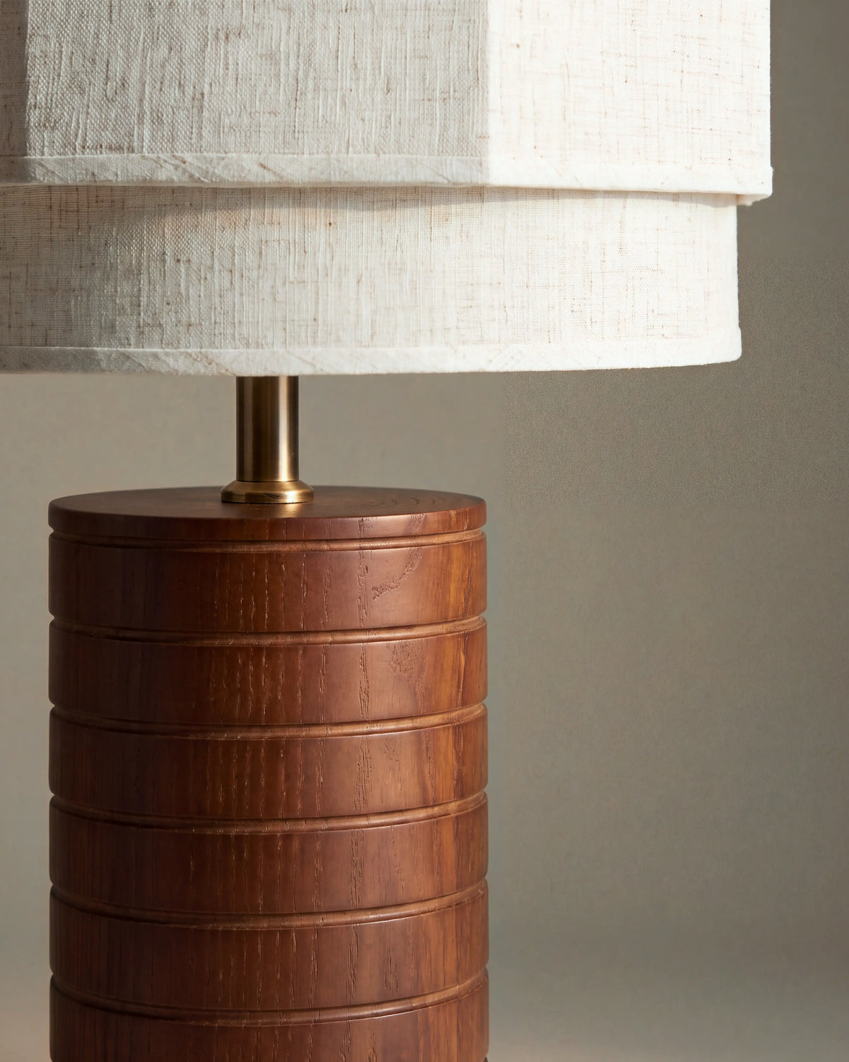 gros plan sur les rainures du pied en noyer et la douille en laiton de la lampe SIA